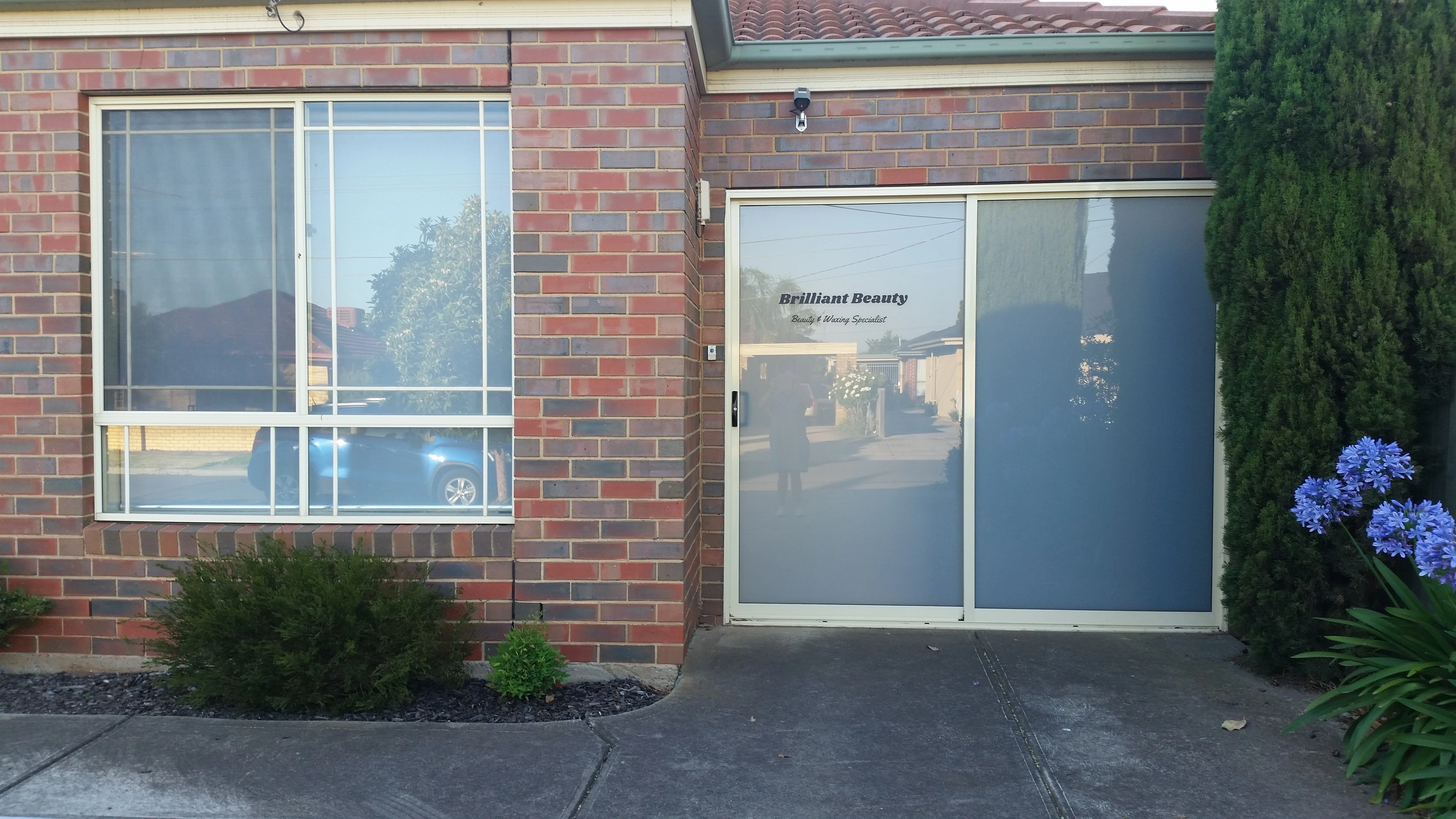 The signed frosted-glass studio door reading 'Brilliant Beauty — Beauty & Waxing Specialist', Ardeer